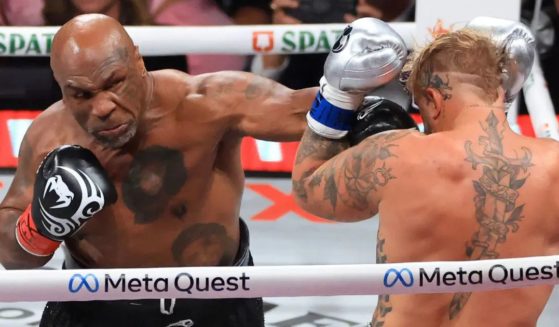 Mike Tyson, left, punches Jake Paul, right, during their heavyweight bout in Arlington, Texas, on Friday.