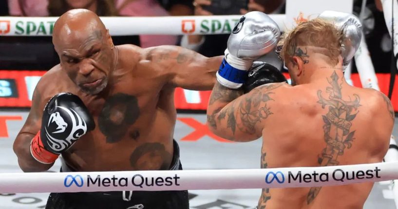 Mike Tyson, left, punches Jake Paul, right, during their heavyweight bout in Arlington, Texas, on Friday.