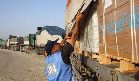 A United Nations employee checks humanitarian aid on a convoy of lorries entering the Gaza Strip from Egypt via the Rafah border crossing in a file photo from Oct. 21, 2023. The United Nations Relief and Works Agency complained this week that one such convoy was "violently looted" while passing through Gaza.