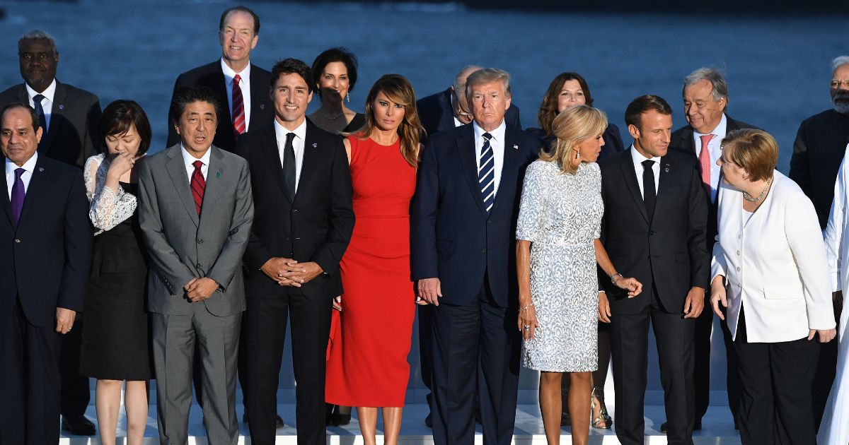 African Union Chair Egyptian President Abdel Fattah el-Sisi, Japanese Prime Minister's wife Akie Abe, Japan's Prime Minister Shinzo Abe, Canada's Prime Minister Justin Trudeau, US First Lady Melania Trump, US President Donald Trump, French President's wife Brigitte Macron, France's President Emmanuel Macron and Germany's Chancellor Angela Merkel join G7 leaders and guests as they gather for a family picture in front of the Biarritz lighthouse on the second day of the annual G7 summit on August 25, 2019 in Biarritz, France.