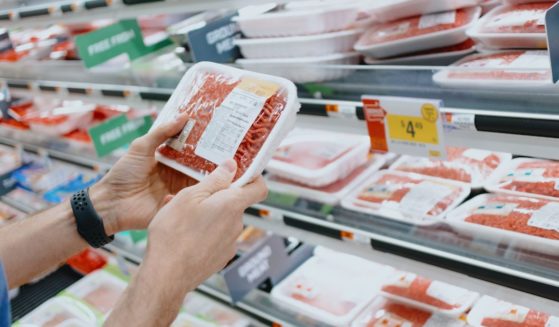 This Getty stock image shows a customer handling a package of ground beef at the supermarket.