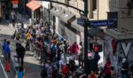 Migrants gather outside of the Roosevelt Hotel where dozens of recently arrived migrants have been camping out as they try to secure temporary housing on August 2, 2023 in New York City.