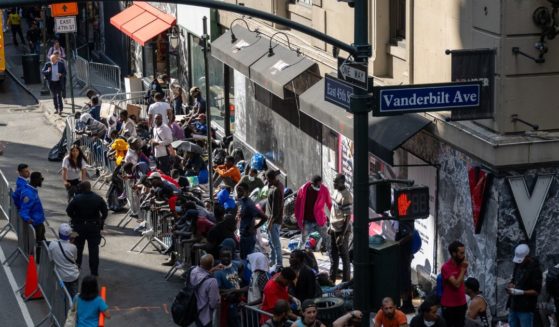 Migrants gather outside of the Roosevelt Hotel where dozens of recently arrived migrants have been camping out as they try to secure temporary housing on August 2, 2023 in New York City.