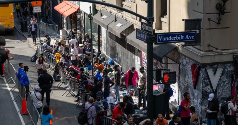 Migrants gather outside of the Roosevelt Hotel where dozens of recently arrived migrants have been camping out as they try to secure temporary housing on August 2, 2023 in New York City.