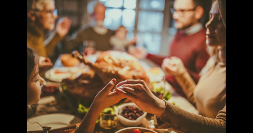 This Getty stock image shows a family praying around a Thanksgiving feast.