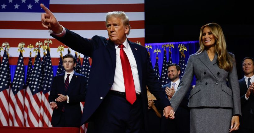 Republican presidential nominee, former U.S. President Donald Trump points to supporters with former first lady Melania Trump during an election night event at the Palm Beach Convention Center on November 6, 2024 in West Palm Beach, Florida.