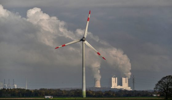 This picture taken on November 12, 2024 shows a wind turbine in front of the lignite-fired power station operated by German energy giant RWE near Neurath, western Germany.