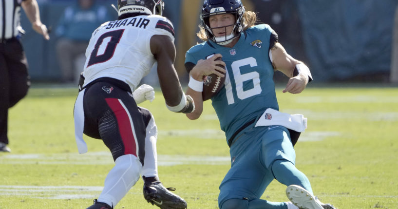 Jacksonville Jaguars quarterback Trevor Lawrence, right, slides in front of Houston Texans linebacker Azeez Al-Shaair, left, during the first half of an NFL football game in Jacksonville, Florida, on Sunday.