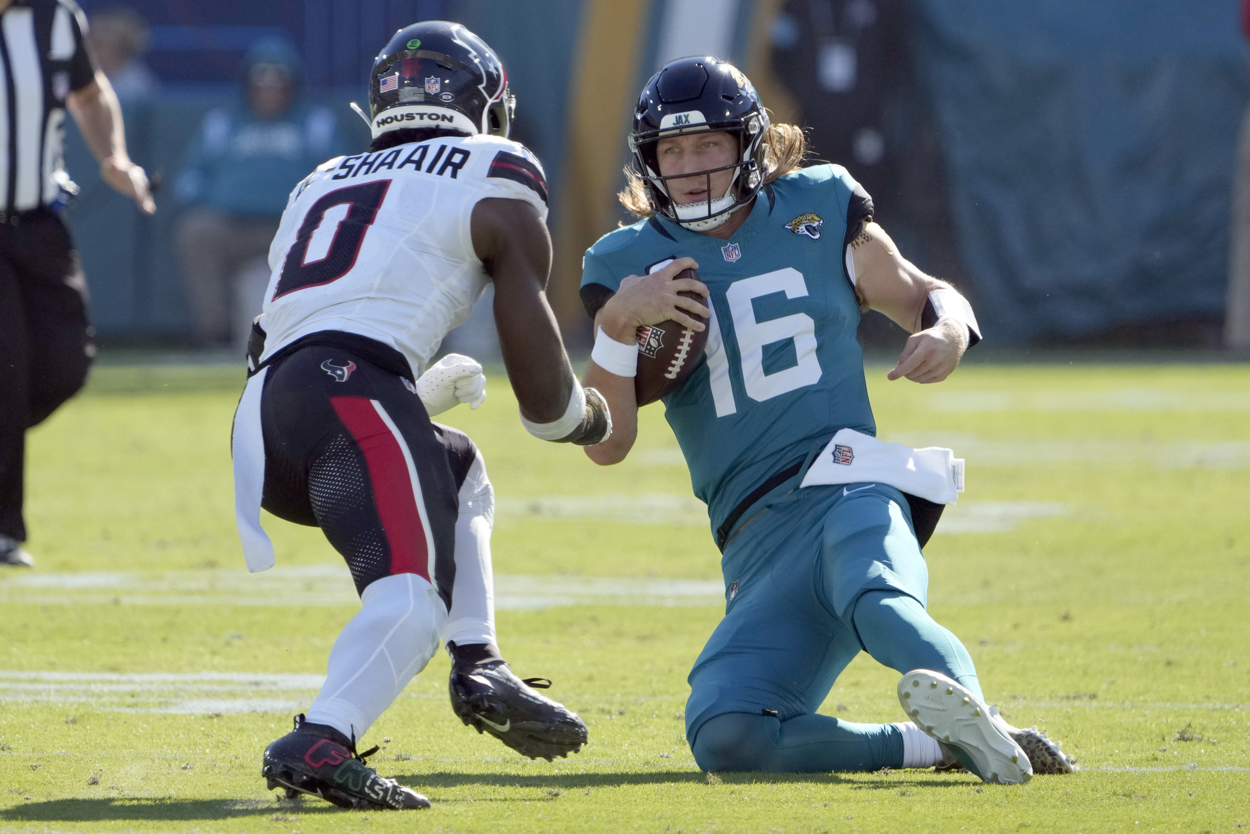 Jacksonville Jaguars quarterback Trevor Lawrence, right, slides in front of Houston Texans linebacker Azeez Al-Shaair, left, during the first half of an NFL football game in Jacksonville, Florida, on Sunday.