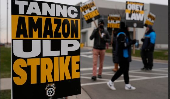 Strikers hold signs during a strike at Skokie Amazon Delivery station Thursday in Skokie, Illinois.