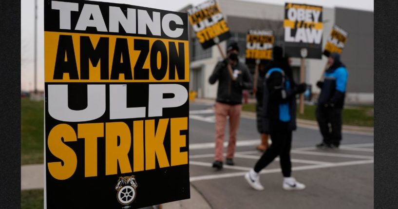 Strikers hold signs during a strike at Skokie Amazon Delivery station Thursday in Skokie, Illinois.