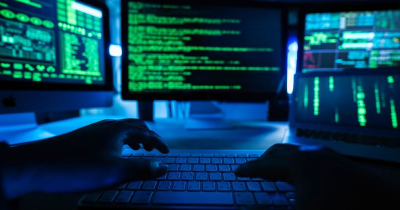 This stock image depicts a computer hacker using a system to hack into a network.