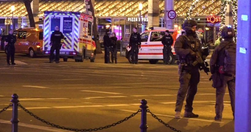 Police and ambulances stand next to the Christmas market, where a car crashed into a crowd Friday, injuring between 