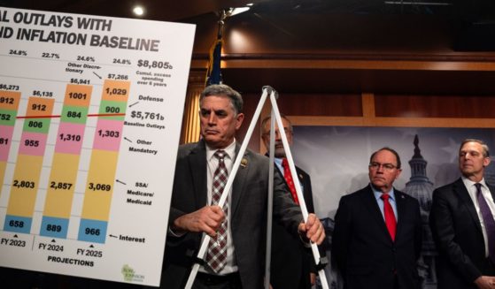 GOP Rep. Andrew Clyde of Georgia helps put up a visual aid for GOP Sen. Ron Johnson of Wisconsin during a news conference on the proposed continuing resolution to extend government funding through March 14.