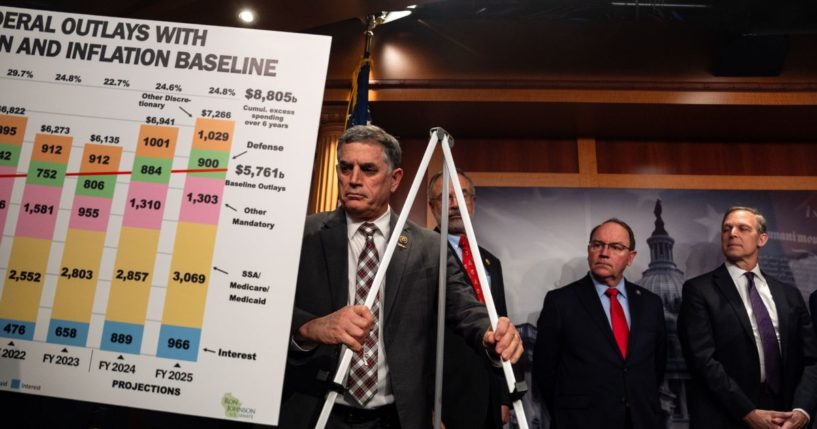 GOP Rep. Andrew Clyde of Georgia helps put up a visual aid for GOP Sen. Ron Johnson of Wisconsin during a news conference on the proposed continuing resolution to extend government funding through March 14.