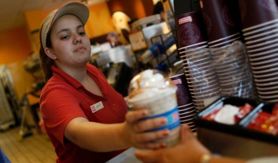 Jennifer Iglesis hands a customer a drink from Dunkin' Donuts in Miami, Florida, on Feb. 26, 2008.