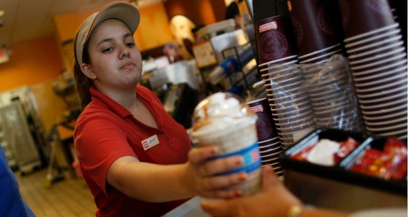 Jennifer Iglesis hands a customer a drink from Dunkin' Donuts in Miami, Florida, on Feb. 26, 2008.