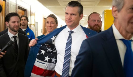 Pete Hegseth, President-elect Donald Trump's choice to be defense secretary, shows a U.S. flag lining on the inside of his suit coat as he arrives for a meeting with GOP Sen. Bill Cassidy of Louisiana on Capitol Hill Wednesday in Washington D.C.