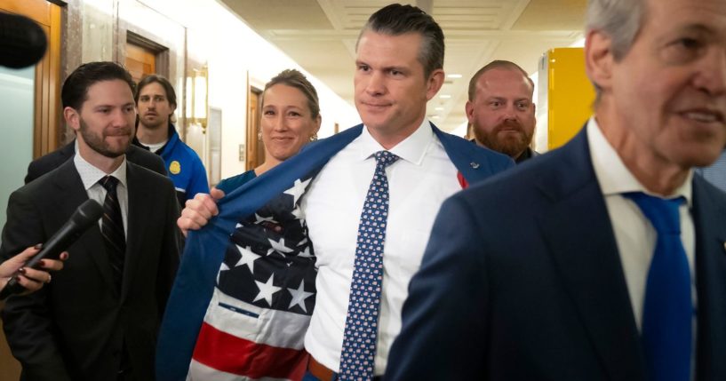 Pete Hegseth, President-elect Donald Trump's choice to be defense secretary, shows a U.S. flag lining on the inside of his suit coat as he arrives for a meeting with GOP Sen. Bill Cassidy of Louisiana on Capitol Hill Wednesday in Washington D.C.