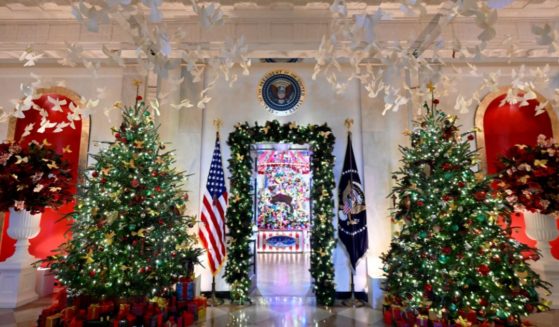 The Seal of the President of the United States sits high above Christmas decorations in the Cross Hall during the 2024 White House Holiday media preview in Washington, D.C., on Monday.