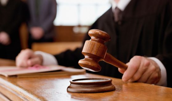 This stock image shows a judge banging his gavel in a courtroom.