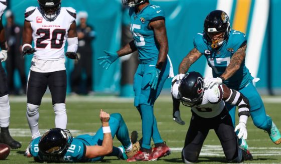 Jacksonville Jaguars tight end Evan Engram, right, reacts to Houston Texans linebacker Azeez Al-Shaair, bottom right, for his hit on quarterback Trevor Lawrence, lower left, during an NFL football game in Jacksonville, Florida, on Sunday.