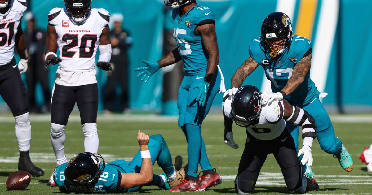 Jacksonville Jaguars tight end Evan Engram, right, reacts to Houston Texans linebacker Azeez Al-Shaair, bottom right, for his hit on quarterback Trevor Lawrence, lower left, during an NFL football game in Jacksonville, Florida, on Sunday.