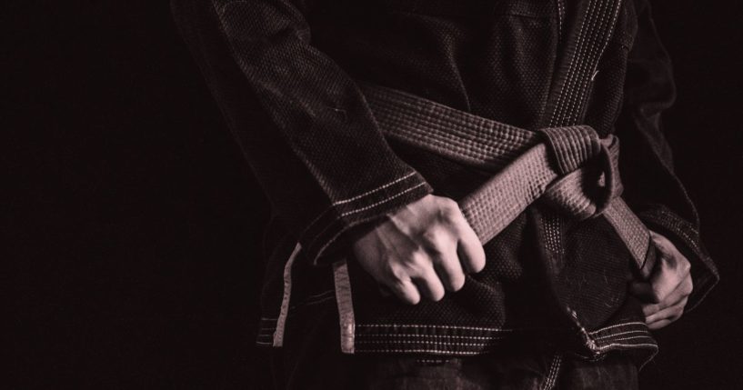 This stock image shows a Brazilian Jiu-Jitsu fighter holding onto his belt.