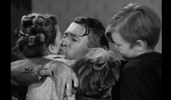 Jimmy Stewart hugging two children in a scene from 1946's "It's a Wonderful Life."