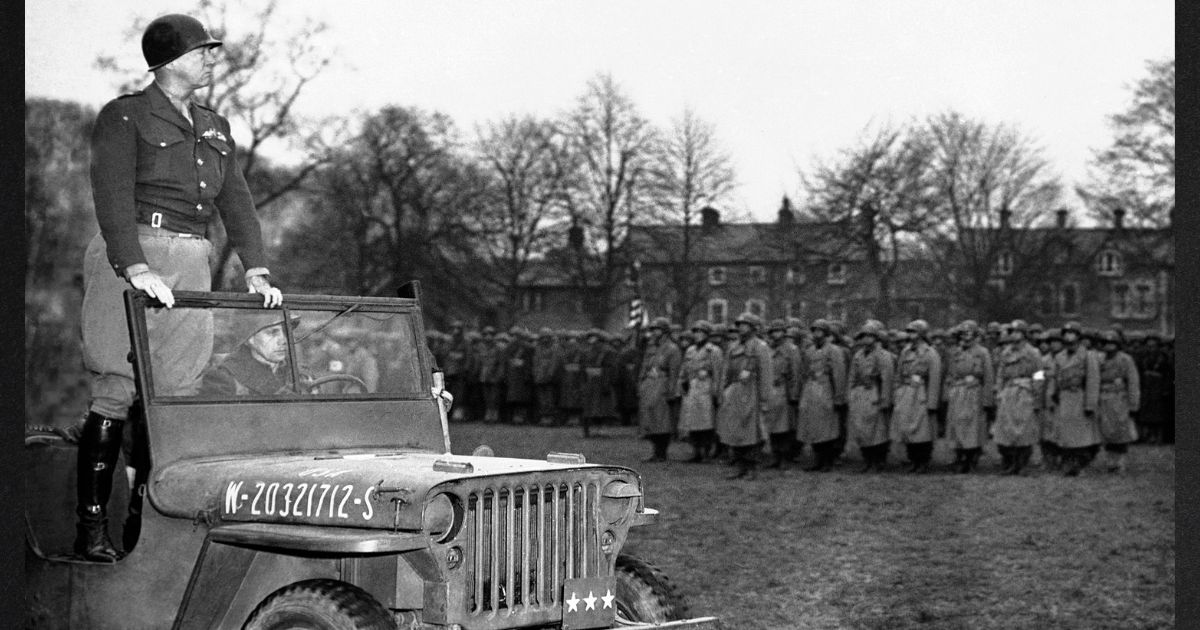 Standing in a jeep, Lt. Gen. George S. Patton reviews troops in Northern Ireland on April 26, 1944.