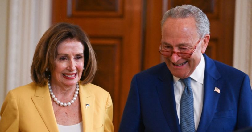 Rep. Nancy Pelosi, left, and Senate Majority Leader Chuck Schumer, right, attend an event on the anniversary of the Inflation Reduction Act in the East Room of the White House in Washington, D.C., on Aug. 16, 2023.