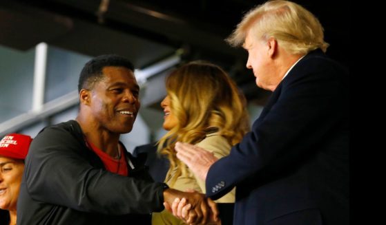 Former football player and political candidate Herschel Walker interacts with former president of the United States Donald Trump prior to Game Four of the World Series between the Houston Astros and the Atlanta Braves Truist Park on October 30, 2021 in Atlanta, Georgia.