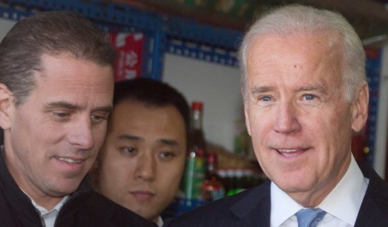 U.S. Vice President Joe Biden, center, buys an ice-cream at a shop as he tours a Hutong alley with his granddaughter Finnegan Biden, right, and son Hunter Biden, left on December 5, 2013 in Beijing, China.