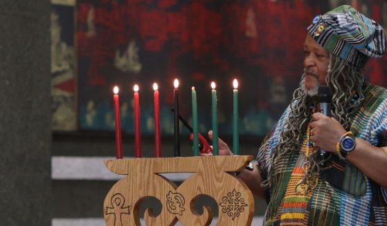 Cyril Innis Jr. lights kinara candles during the Kwanzaa celebration at the African Burial Ground National Monument on December 26, 2023 in New York City.