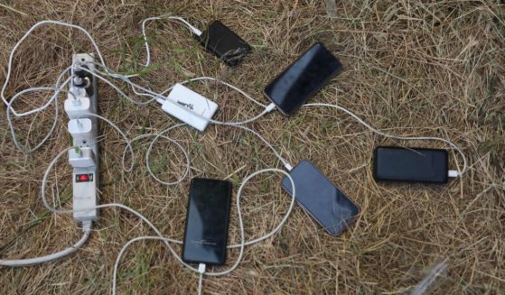 Migrants' cell phones are charged by aid workers in the US as they wait for asylum hearings at the US-Mexico border on May 10, 2023 in San Ysidro, California.