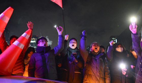 People gesture as they gather outside the National Assembly in Seoul, South Korea, on Wednesday.