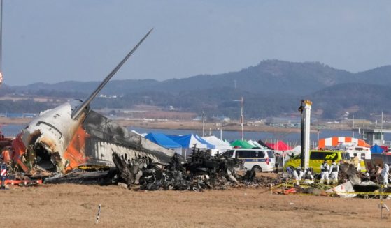 Rescue team members work at the site of a plane fire at Muan International Airport in Muan, South Korea, on Monday.