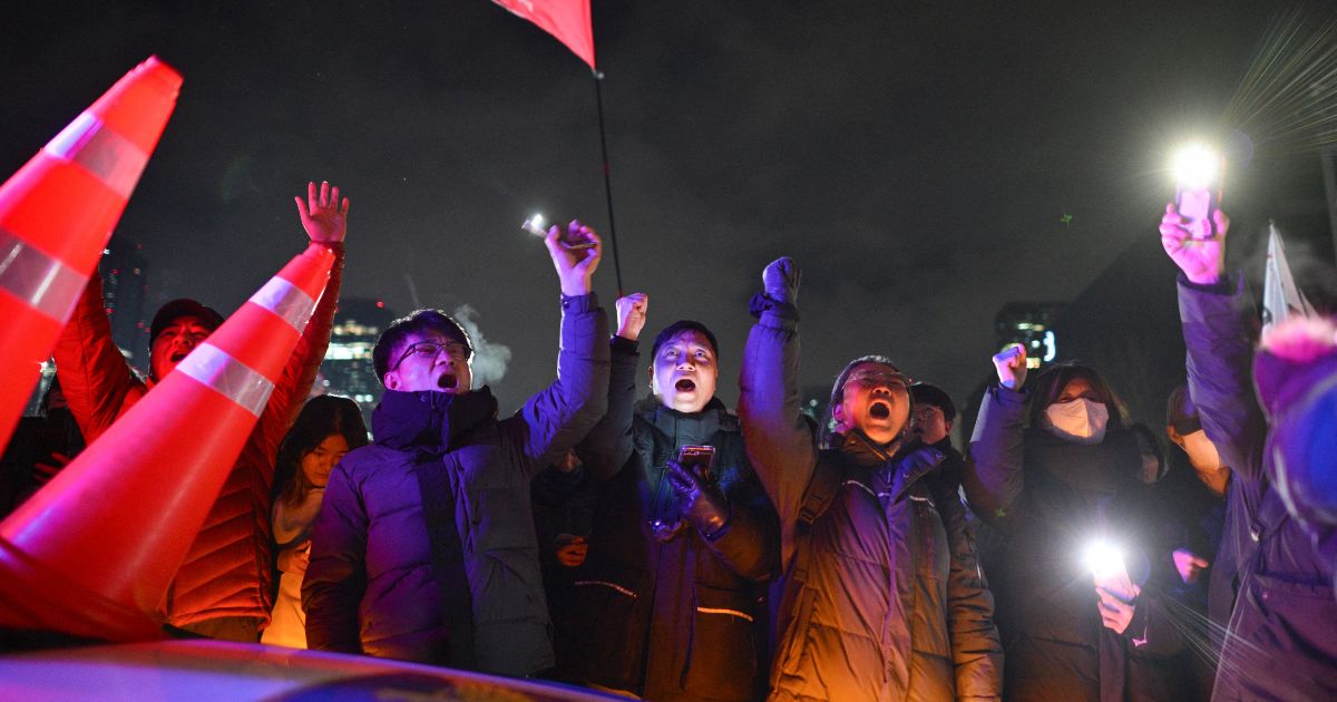 People gesture as they gather outside the National Assembly in Seoul, South Korea, on Wednesday.