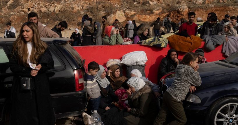 Syrians wait on the road to cross into Lebanon near the Masnaa border crossing on Wednesday.