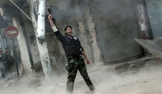 A rebel fighter gestures for victory after firing a shoulder-fired missile toward a building where Syrian troops loyal to President Bashar Assad were hiding as they attempted to gain terrain against the rebels during heavy clashes in the Jedida district of Aleppo, Syria, on Nov. 4.