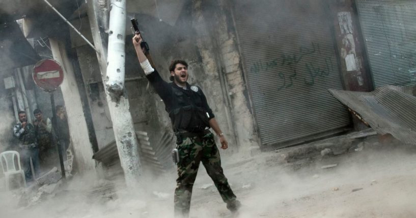 A rebel fighter gestures for victory after firing a shoulder-fired missile toward a building where Syrian troops loyal to President Bashar Assad were hiding as they attempted to gain terrain against the rebels during heavy clashes in the Jedida district of Aleppo, Syria, on Nov. 4.