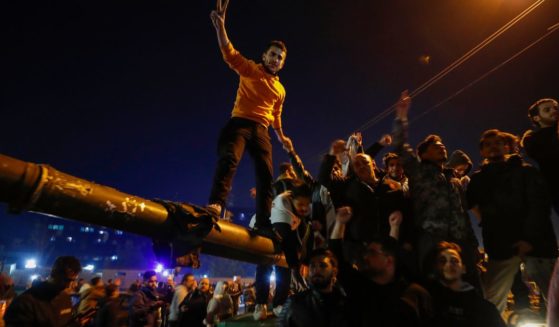 Syrians celebrate the arrival of opposition fighters in Damascus, Syria, on Sunday.