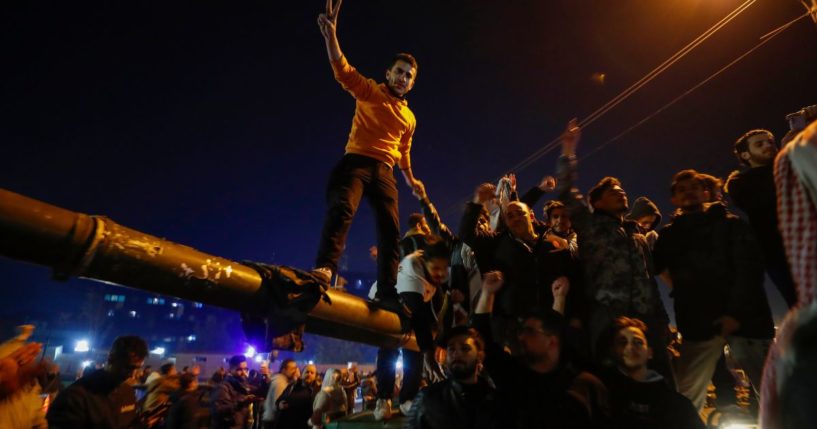 Syrians celebrate the arrival of opposition fighters in Damascus, Syria, on Sunday.