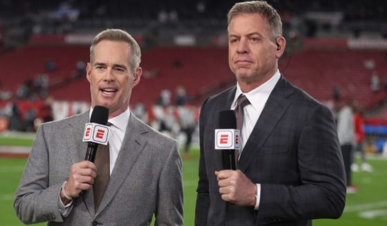 ESPN announcers Joe Buck, left, and Troy Aikman, right, stand on the sideline of the NFC Wild Card Playoff Game in Tampa, Florida, on Jan. 16.