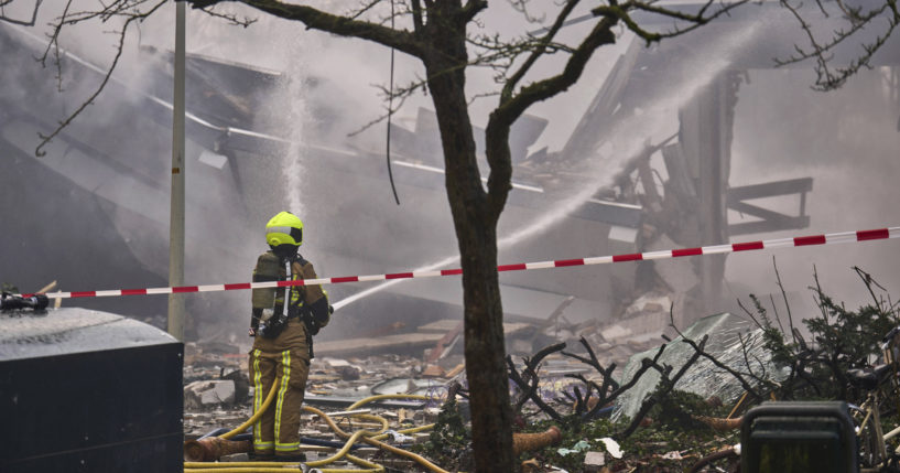 A firefighter hoses down rubble after a blast ripped through the Hague.