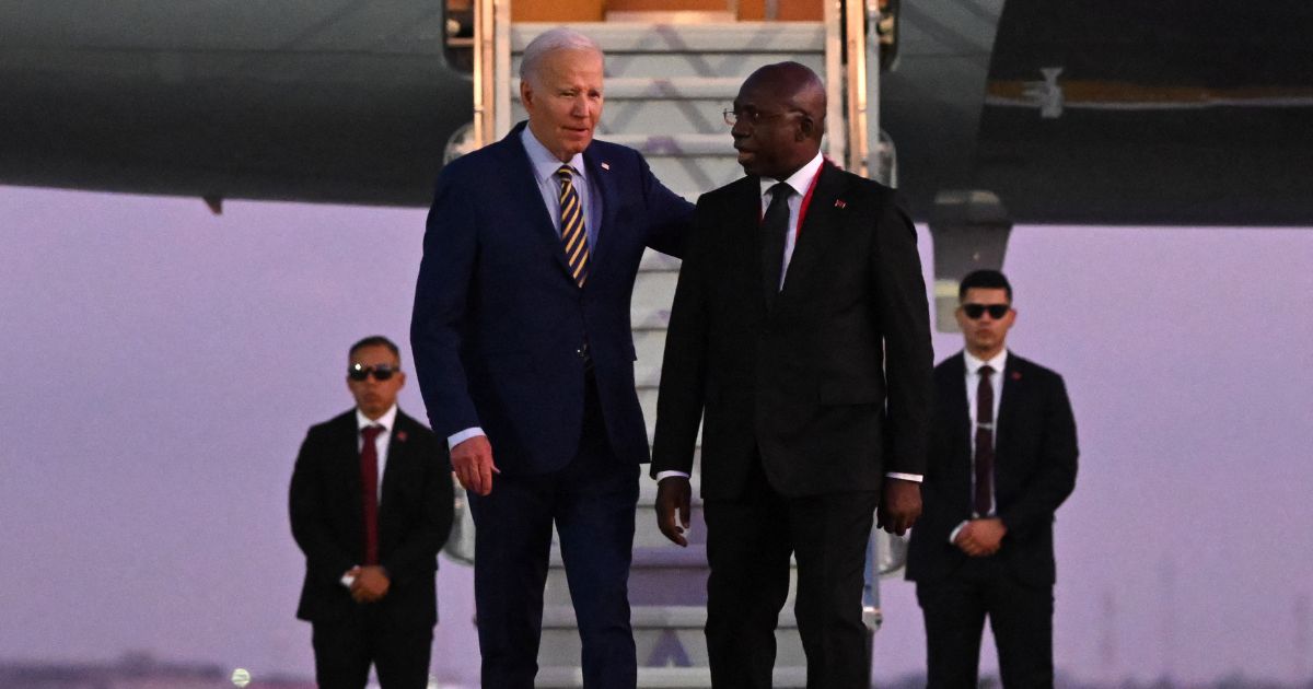 US President Joe Biden (3rd R) walks on the red carpet next to Angola Foreign Affairs Minister Tete Antonio (2nd R) upon his arrival at the Quatro de Fevereiro Luanda International Airport in Luanda on December 2, 2024.