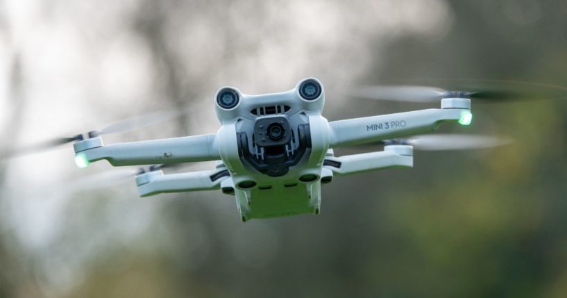 A DJI drone, a Mini 3 Pro, flies above the ground on November 28, 2024 in Glastonbury, England.