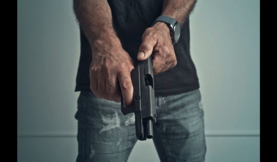 This Getty stock image shows a faceless man loading a handgun.