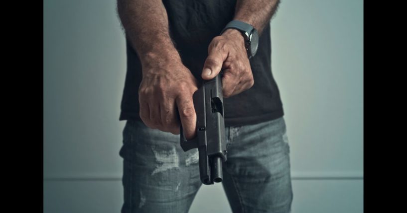 This Getty stock image shows a faceless man loading a handgun.