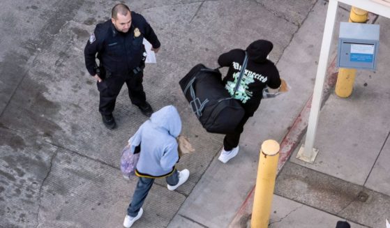 A Customs and Border Protection offer supervises as deportees arrive to cross back into Mexico on Wednesday in Nogales, Arizona. President Donald Trump signed executive orders on his first day in office declaring a state of emergency at the U.S. southern border, halting asylum claims and launching a campaign of mass deportations.